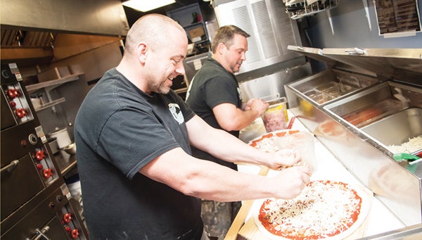 Photo by Brandon Hicks John Seehorn, left, and John Malone work hard in the kitchen at Jiggy Ray's making pizzas. Last year the best friends experienced a dream come true when they opened their own restaurant.