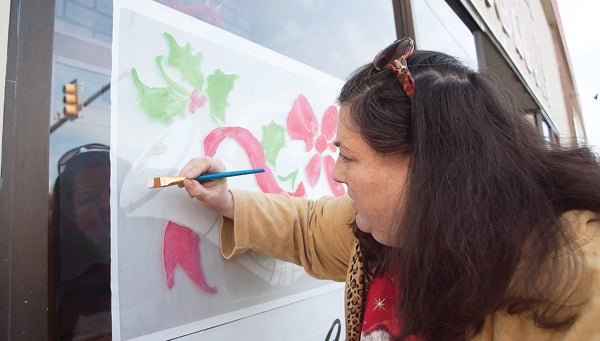Photo by Brandon Hicks Aislinn Ryan works on a window painting at Big John’s Closeouts in downtown Elizabethton.