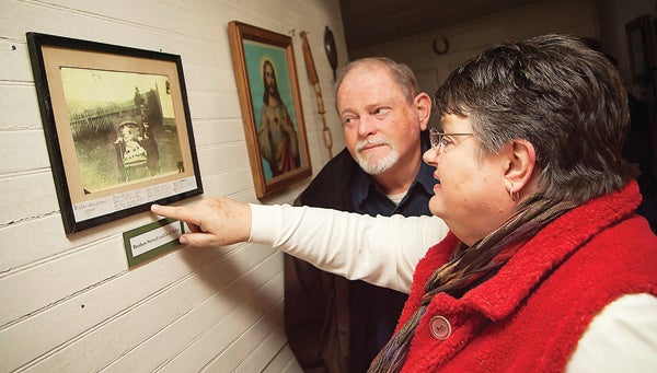 Photo by Brandon Hicks Kathy Miller Deloach looks at an old photograph hanging on the wall of the historic house at Miller Farmstead. Deloach is a descendant of the family that originally settled the farm in 1870, and the photo she is looking at shows her father as a baby. 