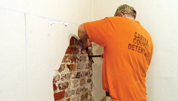 Photo by Abby Morris-Frye An inmate worker removes plaster from one of the walls at the Clerk and Master’s office. Despite the ongoing renovations, the office is still open for business.