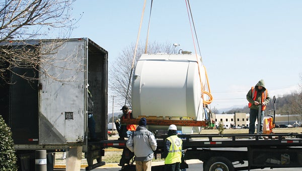 Star Photo/Abby Morris-Frye  The MRI unit was lifted onto the bed of a flatbed trailer. From there, workers transferred it into the trailer for transport.
