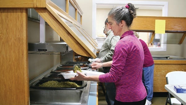 Star Photo/Abby Morris-Frye  Volunteer Michelle McLellan places a scoop of green beans into a boxed dinner.