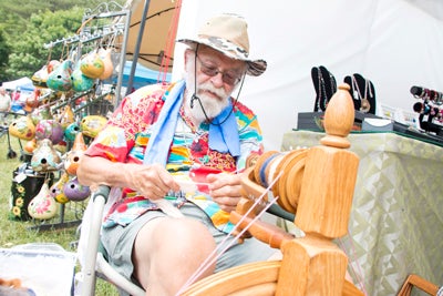 Star Photo/Bryce Phillips     Rudi Anglemaier of Elizabethon spins yard during this year's Rhododendron Festival. Anglemaier's booth was a head turner as many festival patrons stopped to watch Rudi spin his yarn.