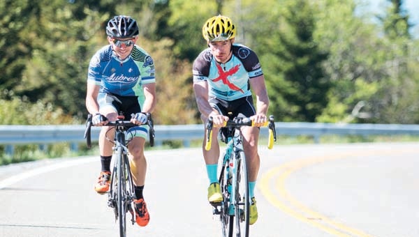 Star Photo/Bryce Phillips Cyclist Drew Bailey, left, and Johnny Mitchell push themselves up the last curve before Carver's Gap as they prepare for the June 6 Roan Groan.
