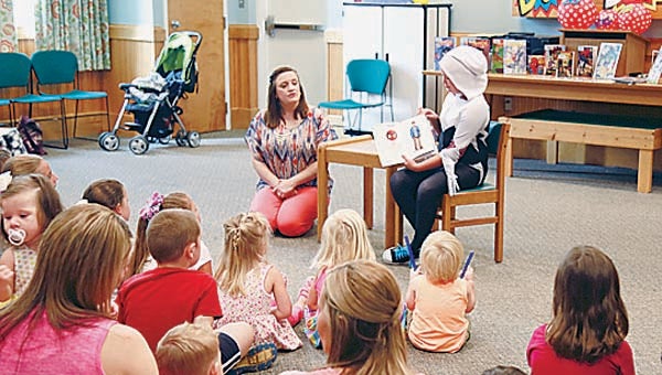Star Photo/Abby Morris-Frye  Madalyn Caulder, aka Spider Gwen, reads a story about another comic book superhero, Spiderman, to children during the Summer Reading Program on Tuesday.