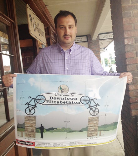 Star Photo/Lynn Richardson Chris Cannon holds a drawing of his vision for the Tweetsie Trail gateway sign for downtown Elizabethton.