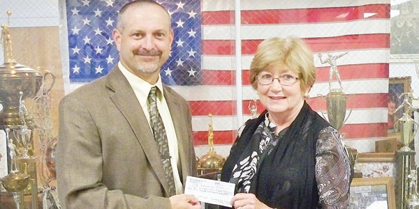 Star Photo/Abby Morris-Frye  Hampton High School Principal Jeff Bradley accepts a check from Carol Ann Nesmith, sister of the late Eddie Jack Miller who left a portion of his estate to the high school and created a scholarship fund at a local college for HHS graduates.