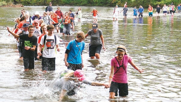 Star Photo/Abby Morris-Frye  While the rain held off so students could participate in the river crossing some, like the the student up front, couldn't avoid getting wet as the crossing proved slippery for some.