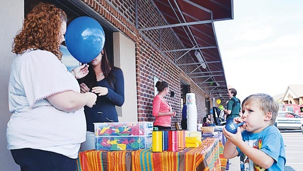 Star Photo/Rebekah Price Berkley Jones, 3, reassured the ladies from Cash Express that he could blow up his own balloon, but agreed to have a helium balloon also.