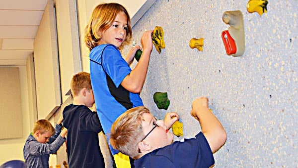 Star Photo/Rebekah Price From left, Mac Paulson, Hayden Bolton, Alex Riddle and Nicholas Perry scale the West SIde climbing wall.