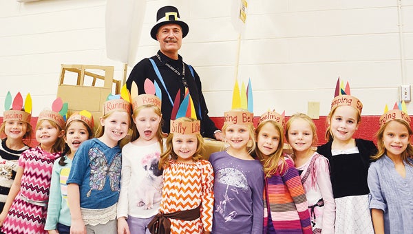 Star Photo/Rebekah Price  Principal John Wright navigates the Mayflower dressed as a pilgrim with numerous first graders dressed as Indians.