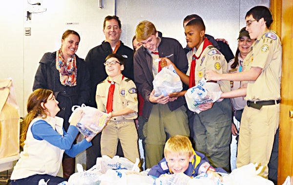 Star Photo/Rebekah Price    (Back row from left) Scout leaders Laura Dean, Michael Lawson, Elizabeth Fair, Keith Lanham and Ricki Dykes deliver food to (front row from left) ARM Executive Director Nikki Jones with Noah Norris, Slade Dean, Deon Langston, Cory Lawson and (front) Asa Dean.