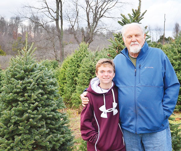 Star Photo/Rebekah Price Eli helps his grandpa Wayne Ayres on their family tree farm.