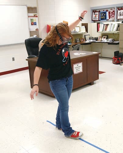 Star Photo/Abby Morris-Frye  Unaka High School sophomore Toni Moffitt tries to walk a straight line while wearing drunk goggles in one of the many events students could participate in during a health fair at the school on Thursday.