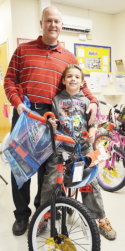 Star Photo/Rebekah Price  Geagley presents Ryan Spates with his new  Christmas bicycle and toys.