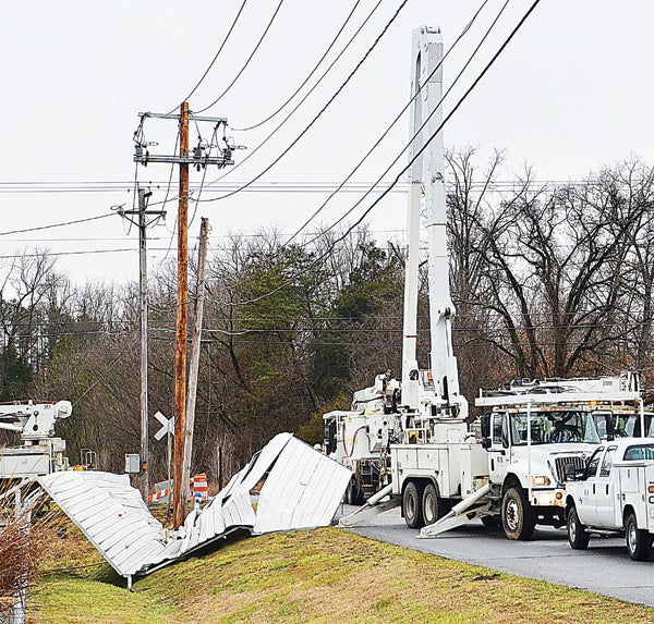 Star Photo/Rebekah Price  Tuesday morning around 10 a.m., employees in the Elizabethton Electrical Department continued work replacing a pole broken by a carport which was blown into its base.
