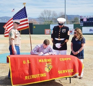 Star Photo/Rebekah Price  Elizabethton High School's Andrew Wetzel signs with the United States Marine Core alongside Staff Sergeant Alexander Baye (left) and his parents Andy and Jenny Wetzel.