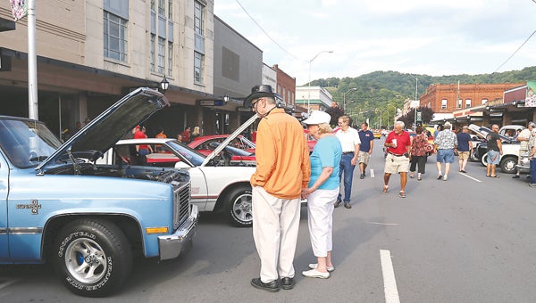 Star File Photo  Cars and trucks line the sides of Elk Avenue in downtown as visitors walk along the sidewalks and in the street to check out the marvels of the automobile. The weekly car show will soon be returning to downtown.