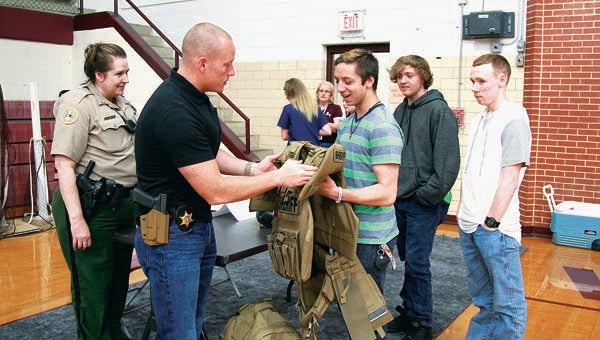 Star Photo/Abby Morris-Frye  Carter County Sheriff's Office Investigator Myles Cook lets a student check out some of the body armor worn by members of the department's Special Weapons And Tactics (SWAT) Team.