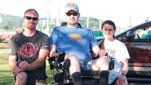 Star Photo/Bryce Phillips  Thursday during the Wheels for Wandell 5K, Jeff Vance, the men's fastest runner, left, and Christin Lowe, the women's fastest racer, pose with Josh Wandell.