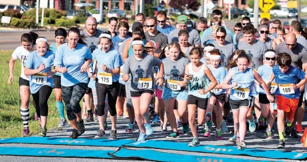 Star Photo/Bryce Phillips  Participants in the Wheels for Wandell 5K take off during Thursday race 's on the Tweetsie Trail.