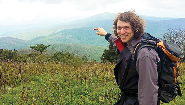 Contributed Photo Eric Rayfield, 2016 ridge runner, points to his home from Grassy Ridge on Roan Mountain, where he will be doing research and educating hikers four days weekly. Aside from his experience in environmental education, one of his hiring managers said he was selected because he is from the area and is passionate about the rare ecosystem of the Roan.