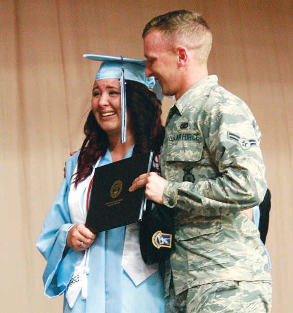 Star Photo/Abby Morris-Frye Mackenzie Henegar received a special surprise as she crossed the stage Friday night at Hampton High School's graduation. Her older brother, Josh Henegar, who is stationed at Lackland Air Force Base, made a surprise trip in to attend the ceremony.