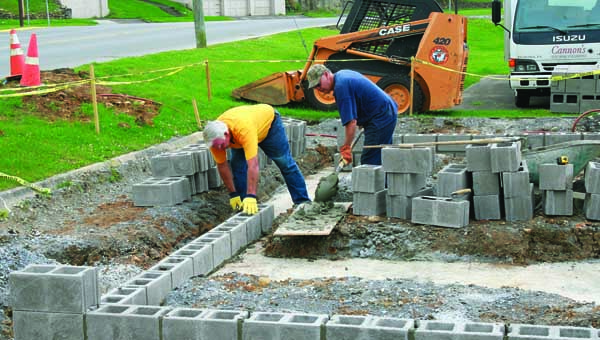 Star Photo/Abby Morris-Frye Carter County Car Club members Randy Payne, left, and Lynn Taylor work to lay block for the bathrooms being constructed downtown as a joint partnership between the club and the City of Elizabethton.