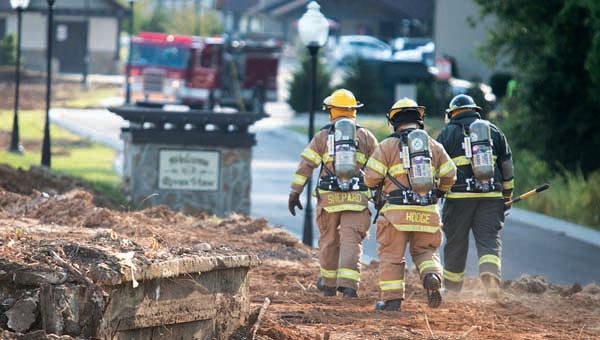 Star Photo/Bryce PhillipsMonday evening, firefighters make their way out to test the temperature of a burning tank that is located off of Stonewall Jackson Drive near River View Townhomes in Elizabethton.