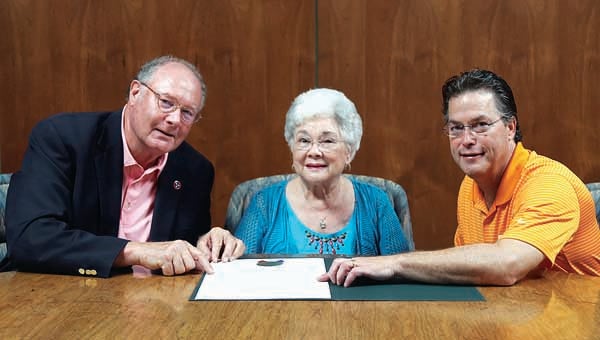Star Photo/Abby Morris-Frye  State Sen. Rusty Crowe, left, and State Rep. John Holsclaw Jr., right, present Charolotte Dugger, center, with a Senate Resolution honoring her late husband Carmon E. Dugger Sr.