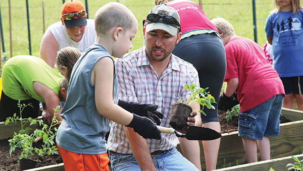 Unaka agricultural teacher Josh Armentrout works with a student involved with the Carter Cares summer program.